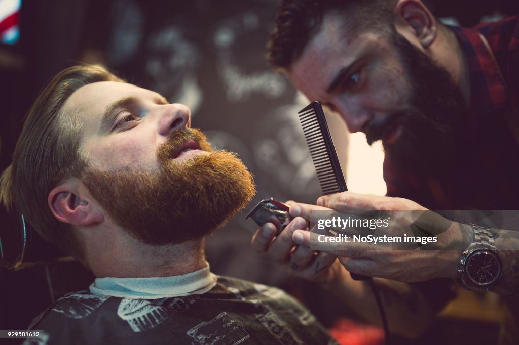 Gingembre, barbu gars à la boutique du coiffeur