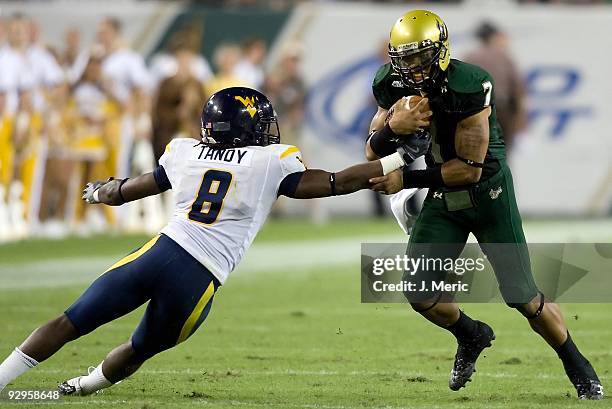 Quarterback B.J. Daniels of the South Florida Bulls runs out of the grasp of defender Keith Tandy of the West Virginia Mountaineers during the game...