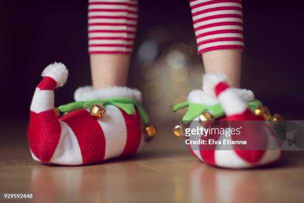 child wearing christmas elf novelty slippers with bells - christmas elf stock-fotos und bilder