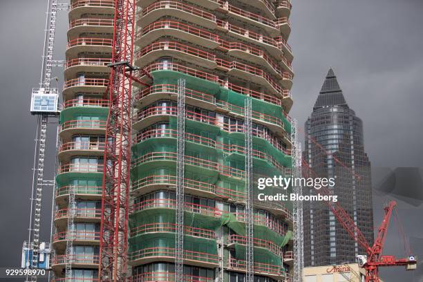 Construction work continues on the high-rise residential property Grand Tower, center, as the MesseTurm skyscraper stands beyond in Frankfurt,...