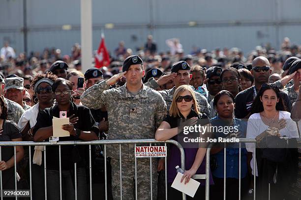 People attend the memorial service that U.S. President Barack Obama and first lady Michelle Obama are attending for the thirteen victims of the...