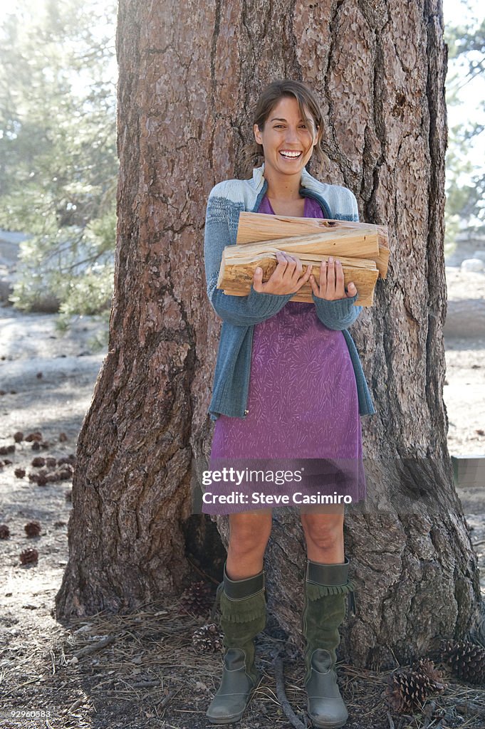 Woman gathers wood for campfire.