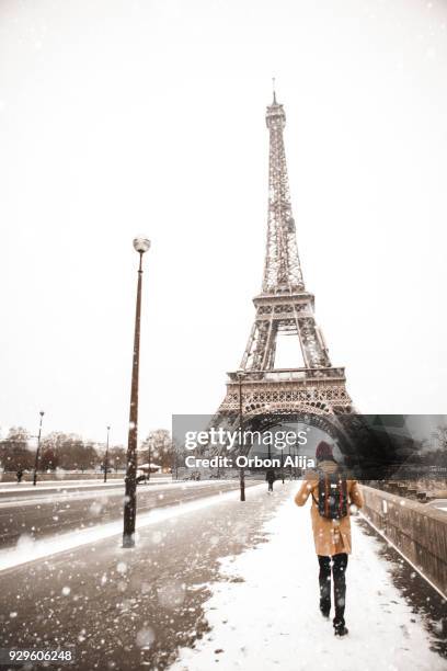 man walking to the eiffel tower with snow - eiffel tower christmas stock pictures, royalty-free photos & images