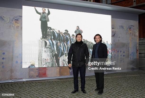 Michele Malenotti and Manuele Malenotti , Vice presidents of Belstaff, pose in front of a video display that shows images from the former Berlin wall...