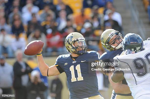 Quarterback Bill Stull of the University of Pittsburgh Panthers passes behind the blocking of offensive lineman Lucas Nix during a college football...