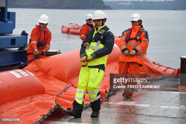 Crew members of the anti-pollution vessel "Argonaute" unwind a floating dam during a drill on March 6, 2018 in Brest, western France. On March 16,...