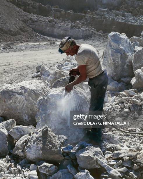 Worker working in an alabaster quarry, Volterra, Tuscany, Italy.