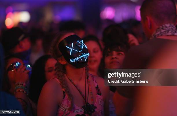 An attendee dances in an illuminated Halloween mask during DJ/producer Space Jesus's performance as he opens up for Datsik during a stop of the Ninja...