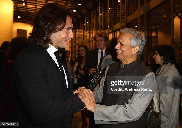 Manuele Malenotti , vice president of Belstaff, shakes hands with economist Muhammad Yunus at the gala dinner BELSTAFF FOR PEACE to the 10th World...