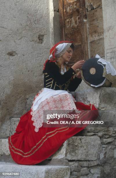 Woman wearing traditional clothes working on a bobbin, Pescocostanzo, Abruzzo, Italy.