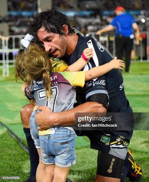 Johnathan Thurston of the Cowboys hugs his daughters Frankie and Charlie at the end of his 300th NRL match during the round one NRL match between the...