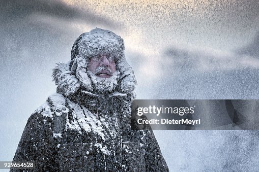 Escena invernal de un hombre con barba completa temblando en una tormenta de nieve y Furry Escena invernal de un hombre con barba completa temblando en una tormenta de nieve y Furry