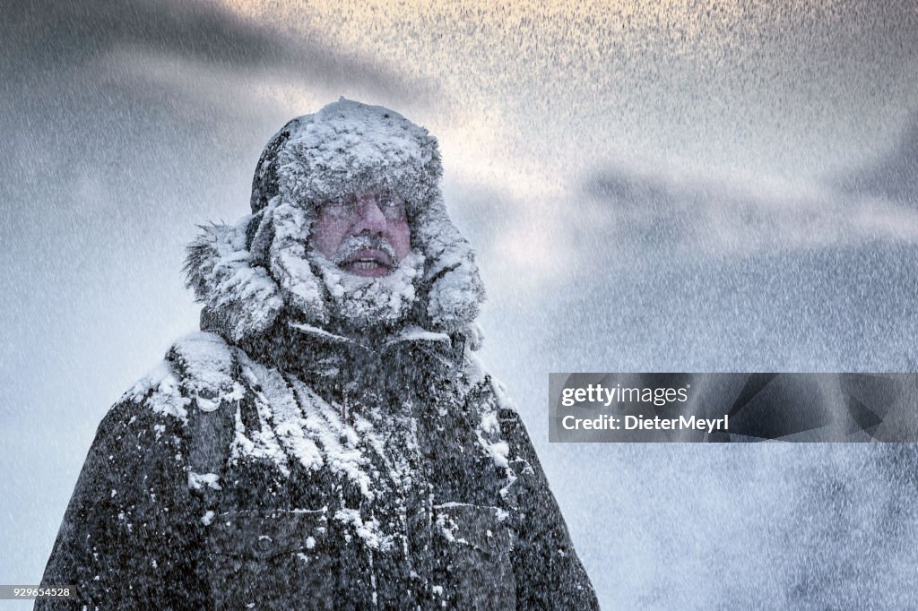 Scène hivernale d’un homme avec Furry et barbe frissons dans une tempête de neige