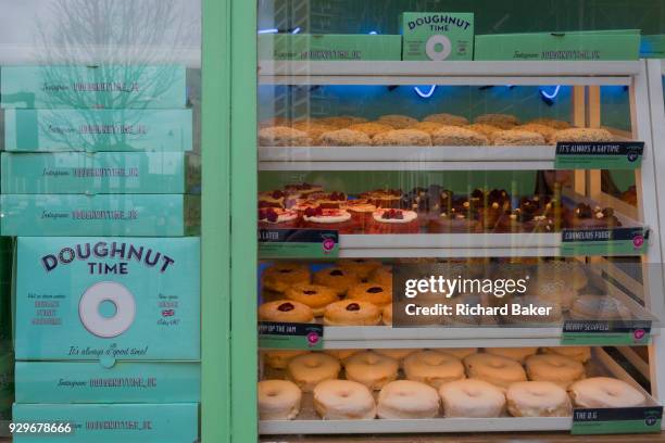 The enticing shop window of Doughnut Time on Old Street in Shoreditch and near Old Street roundabout, 7th March 2018, in London England. Doughnut...