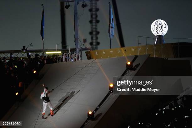 Sledge hockey player Han Min Su of South Korea climbs via rope with the torch during the opening ceremony of the PyeongChang 2018 Paralympic Games at...