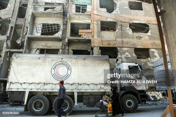 Picture taken on March 9, 2018 shows Syrian Red Crescent trucks carrying humanitarian aid in the Syrian town of Douma in the rebel-held enclave of...