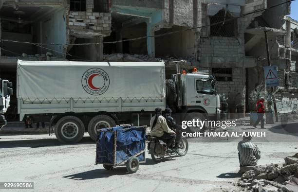 Picture taken on March 9, 2018 shows Syrian Red Crescent trucks carrying humanitarian aid in the Syrian town of Douma in the rebel-held enclave of...