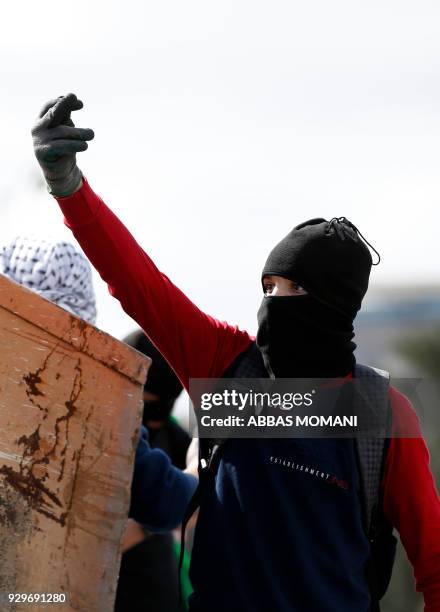 Palestinian protester gives the middle finger during clashes with Israeli border guards following a demonstration in the West Bank city of Ramallah...