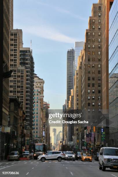 looking down a street lined with skyscrapers - high street banks stock pictures, royalty-free photos & images