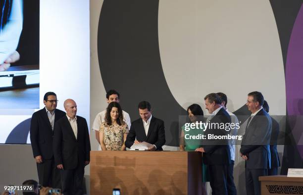 Enrique Pena Nieto, Mexico's president, center, signs a bill regulating the financial technology sector during the Banks of Mexico Association Annual...