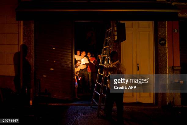Customers at a restaurant hold candles during a massive blackout on November 10, 2009 in Rio de Janeiro. The loss of power across the southern half...