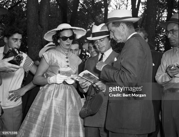 Mr and Mrs C.V. Whitney study race forms with Prince Aly Khan , Saratoga, New York, c1953