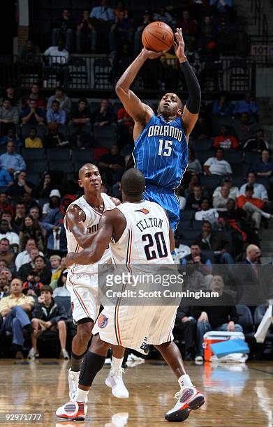 Vince Carter of the Orlando Magic puts up a shot over Raja Bell and Raymond Felton of the Charlotte Bobcats on November 10, 2009 at the Time Warner...