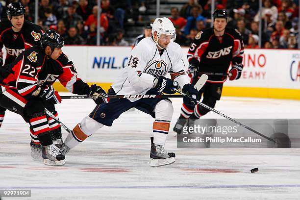 Patrick O'Sullivan of the Edmonton Oilers tries to break away from the Chris Kelly of the Ottawa Senators in NHL action at Scotiabank Place on...