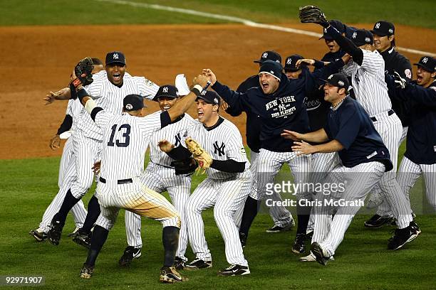 Mariano Rivera and Mark Teixeira of the New York Yankees run towards Alex Rodriguez and his teammates as they celebrate after their 7-3 win against...