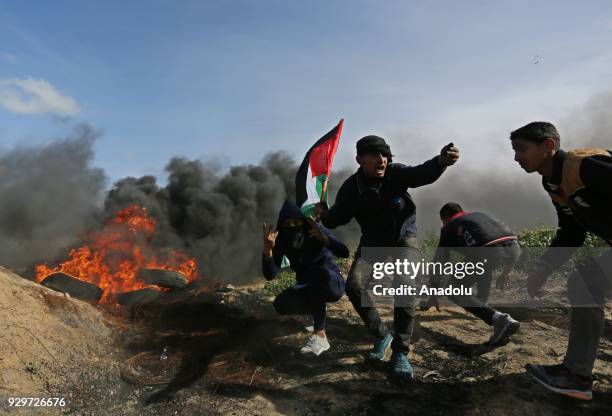 Palestinian protesters burn tyres in response to Israeli forces' intervention during a demonstration to protest against U.S. President Donald Trump's...