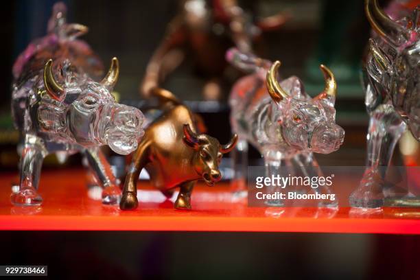 Charging Bull statue figurines are displayed for sale in a souvenir shop near the New York Stock Exchange in New York, U.S., on Friday, March 9,...