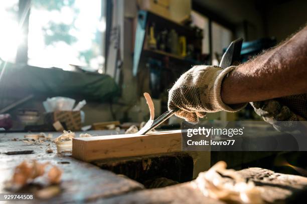 en erfaren snickare formar trä med en mejsel - carving craft activity bildbanksfoton och bilder