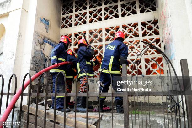 Bangladeshi Fire-fighters douse flames that burnt goods stored by hawkers at a marketplace by the Baitul Mukarram mosque in Dhaka, Bangladesh, March...