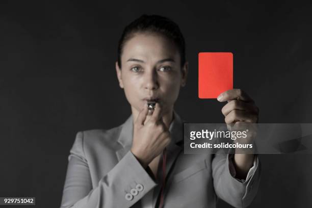 business woman holding red card and blowing a whistle - red card stock pictures, royalty-free photos & images