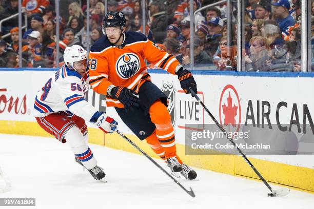 Anton Slepyshev of the Edmonton Oilers is pursued by John Gilmour of the New York Rangers at Rogers Place on March 3, 2018 in Edmonton, Canada.