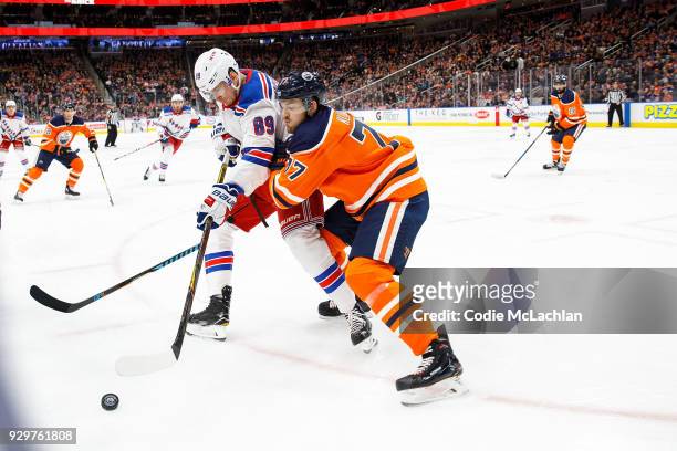 Oscar Klefbom of the Edmonton Oilers battles against Pavel Buchnevich of the New York Rangers at Rogers Place on March 3, 2018 in Edmonton, Canada.