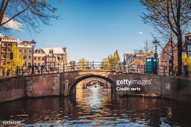 stadtbild von amsterdam mit kanal und brücken in niederlande - amsterdam stock-fotos und bilder
