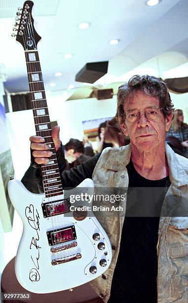 Musician Lou Reed holds up a signed guitar as he attends the 6th Annual Ten O'Clock Classics benefit gala at the The Union Square Ballroom on...