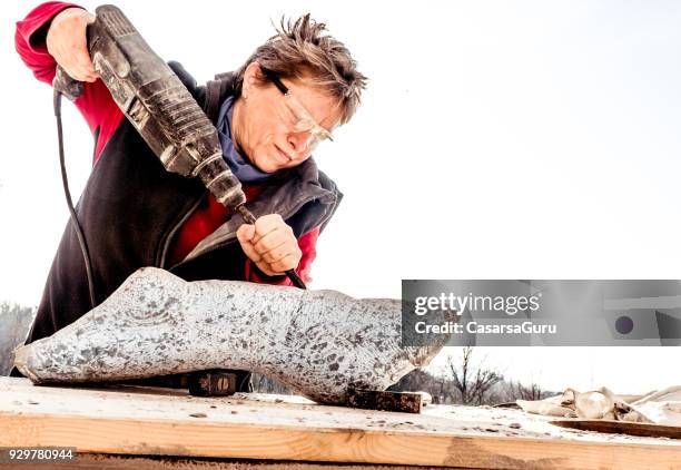 mature woman making sculpture from repen stone - facing things head on stock pictures, royalty-free photos & images