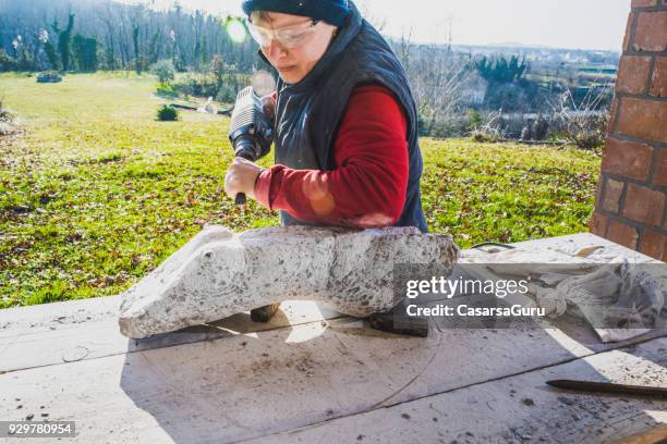 mature woman making sculpture from repen stone - facing things head on stock pictures, royalty-free photos & images