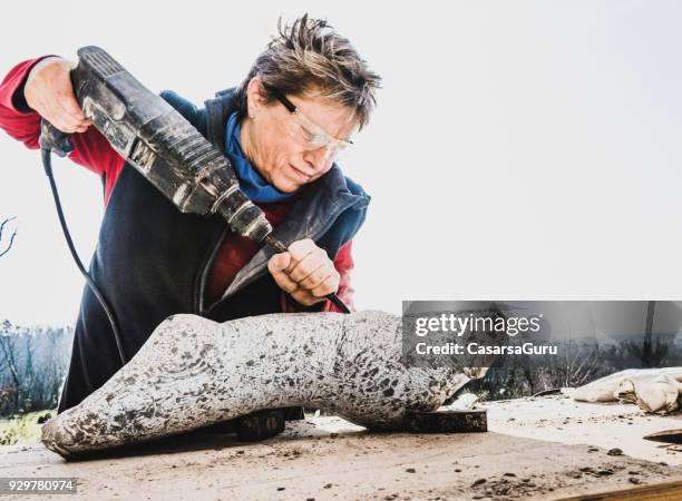 mature woman making sculpture from repen stone - facing things head on stock pictures, royalty-free photos & images