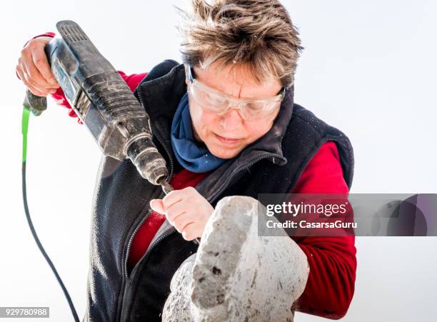 mature woman making sculpture from repen stone - facing things head on stock pictures, royalty-free photos & images