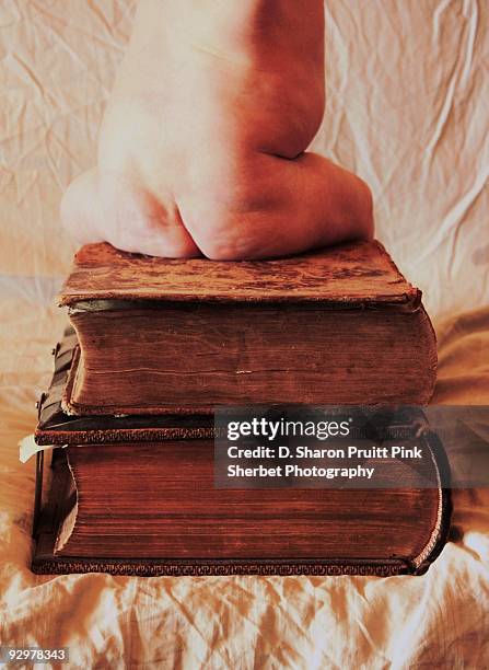 book bum baby sitting on old antique books - boys bare bum stock pictures, royalty-free photos & images