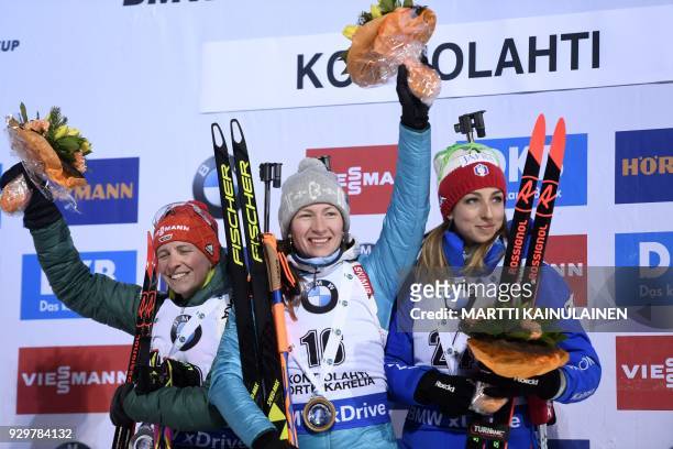 Second placed Franziska Hildebrand of Germany, winner Darya Domracheva of Belarus and third Lisa Vittozzi of Italy celebrate on the podium after the...
