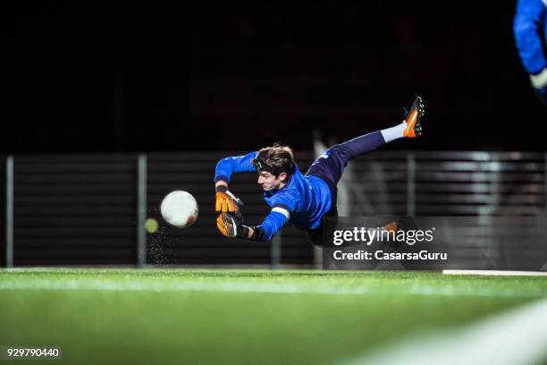 goalkeeper catching the ball in mid air - goalie goalkeeper football soccer keeper stock pictures, royalty-free photos & images