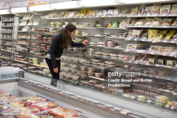 young woman shopping in convenience store - tante emma laden stock-fotos und bilder