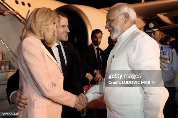 French President Emmanuel Macron and his wife Brigitte meets Indian Prime minister Narendra Modi on March 9, 2018 at New Delhi's military airport as...