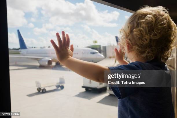 boy (2-3) looking at airplanes on airport runway - kid in airport stock-fotos und bilder