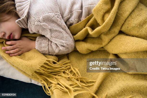 girl (4-5) lying on sofa covered with blanket - blanket stock pictures, royalty-free photos & images