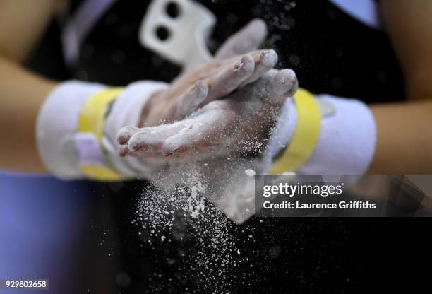 Gymnast chalks her hands during The Women's Junior All-Around Subdivision 1 Round during the Gymnastics British Championships at Echo Arena on March...